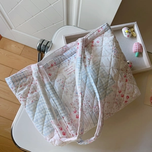 Detailaufnahme der gesteppten Baumwolltasche mit Blumenmuster und weichem Stoffetikett