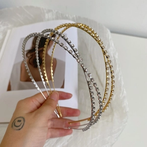 Close-up of gold and silver rhinestone crossover headbands with double-layer metal design
