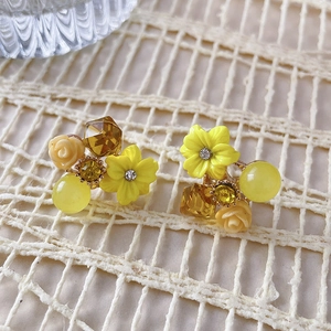 Close-up of yellow flower earrings with cat eye stones and crystal resin flower petals