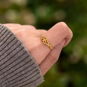 Minimalist s925 silver Trinity Knot ring in gold finish worn on finger, elegant style
