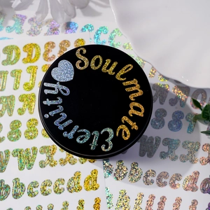 Detail of glitter alphabet stickers with soulmate and eternity text on black containers