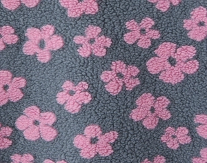 Close-up of soft grey fleece fabric with pink floral patterns and plush texture