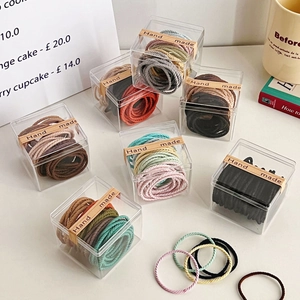 Macro shot of assorted colorful spiral elastic hair ties in a clear gift box display