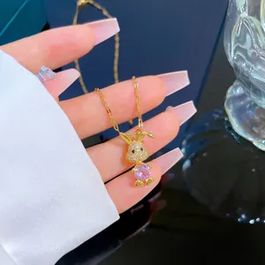 Macro shot of gold-plated pink rabbit pendant necklace with zircon crystals for women