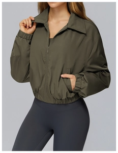 Detail of dark olive windproof jacket with zip-up collar and elastic cuffs and hem