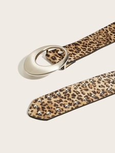 Gros plan sur une ceinture léopard avec boucle argentée ovale et rivets métalliques