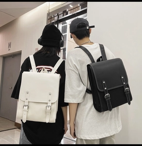 Detail of minimalist vintage faux leather backpacks in black and white worn by models