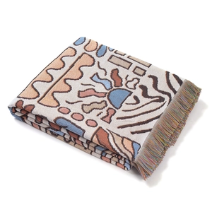 Detailed view of bohemian woven blanket featuring colorful fringes and jacquard texture