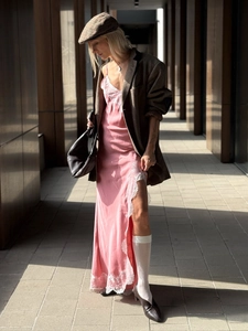 Détail d'une robe nuisette en satin rose avec dentelle blanche et fente haute