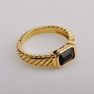 Detailed view of a gold titanium ring featuring a rectangular black zircon and ribbed texture