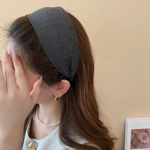 Detail eines dunkelgrauen breiten Strickstirnbands mit weicher Textur an einem Modell