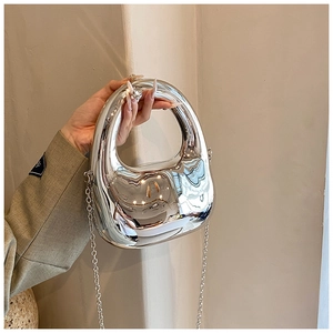Close-up of a silver molten-shaped acrylic handbag with mirror finish and metal chain