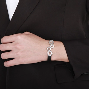 Detail of black leather braided bracelet with silver hexagonal metal nuts on male wrist