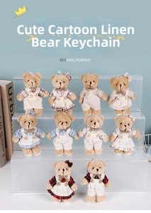 Detail view of ten teddy bear plush keychains in various colorful linen outfits