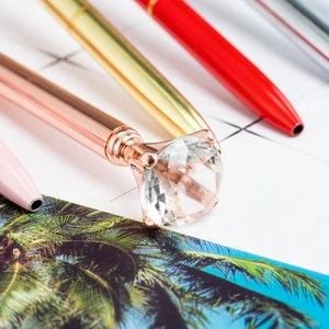 Rose gold metal ballpoint pen with large crystal diamond top and shiny metallic finish