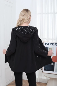 Back view of a long black hooded jacket with stylish polka dot lining and waist belt detail