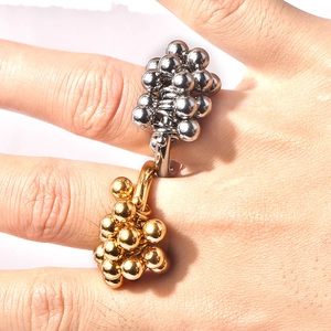 Macro shot of unique gold bead cluster ring with high-polished mirror finish and texture