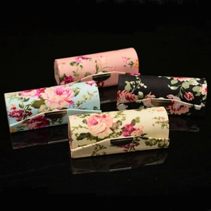 Macro shot of retro floral silk lipstick cases in four colors with metal buttons