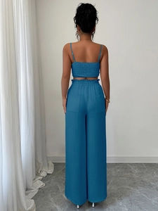 Dettaglio di un completo blu a due pezzi con top arricciato dietro e pantaloni larghi
