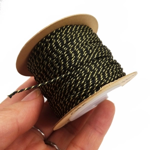 Detail showing 1mm black and gold braided cord on a spool for DIY jewelry making