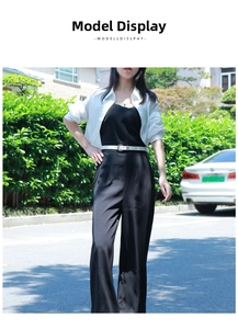 Outdoor look featuring a white blouse, black high-waisted trousers, and a thin white belt