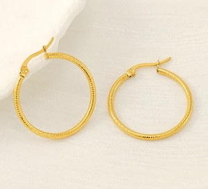 Macro detail of 18k gold plated hoop earrings showing refined spiral texture and secure clasp