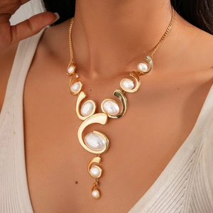 Close-up of a model wearing a golden spiral necklace with white oval acrylic stones