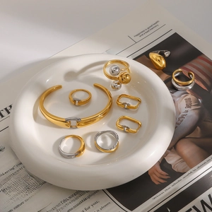 Minimalist bicolor stainless steel jewelry set featuring open bangles and sleek rings