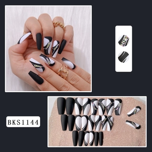 Detail of long coffin press-on nails with black and white wave design and rhinestones