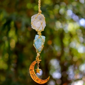 Detail of hand-woven crystal car charm with raw stones and gold star moon pendants