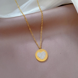 Detail view of heart-shaped crystal pendant on a gold titanium steel necklace chain