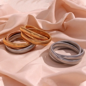Close-up of three-layered flexible Tubogas snake chain bracelets in tri-color gold finishes