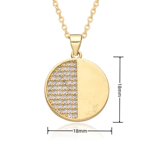 Macro detail of a 18mm golden disc pendant necklace with pavé-set cubic zirconia stones