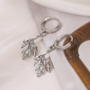 Detail shot of silver leaf-shaped drop earrings with micro-set sparkling zircon stones