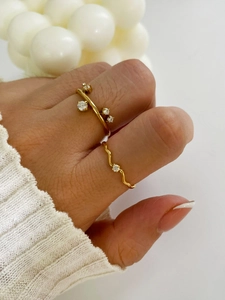 Detail of 18K gold plated zircon wave ring set on hand with minimalist aesthetic