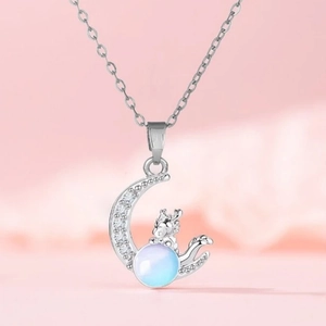 Detailed view of silver dragon and crescent moon pendant with sparkling zircon on pink base