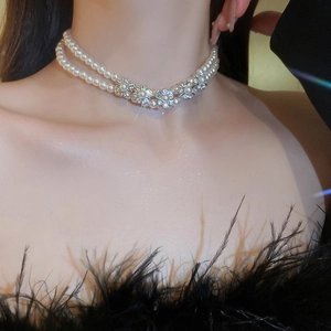 Close-up of double-layered pearl necklace with crystal flower on model neck
