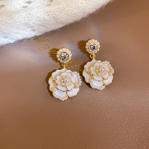 Vintage palace style white floral earrings with pearls and crystals on a gold setting