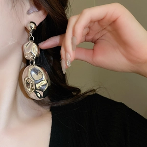 Close-up of chunky silver irregular metal earrings worn by a model for a bold statement look