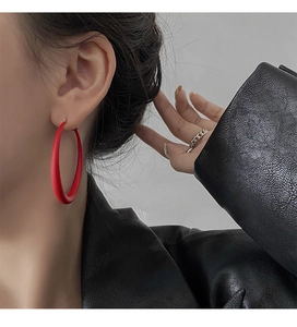 Close-up of matte red hoop earring on a model with black leather jacket contrast