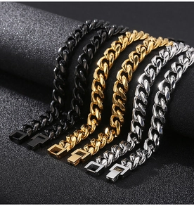Close-up of black, gold and silver stainless steel Cuban link chains with square clasps