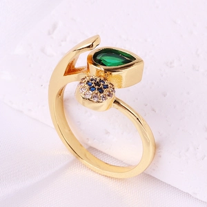 Detailed side view of golden adjustable ring with green zircon on white stone base