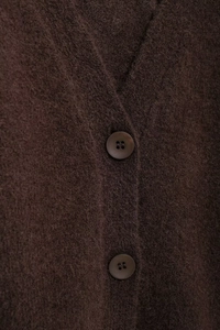 Makroaufnahme der braunen Strickjacke mit V-Ausschnitt und edlen Harzknöpfen