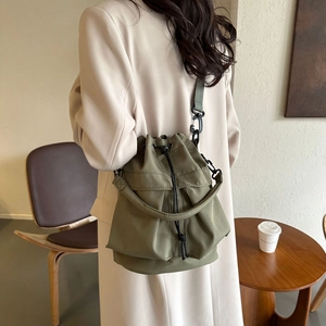 Détail du sac seau en nylon vert armée avec cordon de serrage et bandoulière réglable