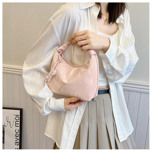 Pink patent leather hobo bag with a wide knot handle and pearl charm detail