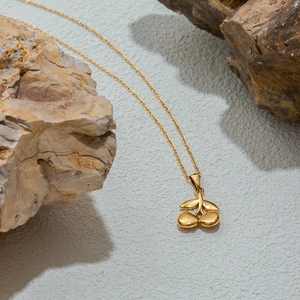Detail of 18K gold-plated stainless steel necklace with pink zircon cherry pendant