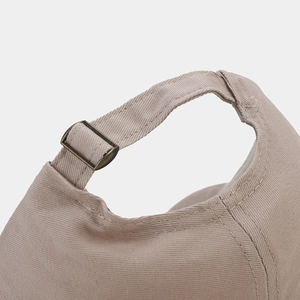 Detail of adjustable metal buckle and stitching on khaki cotton baseball cap