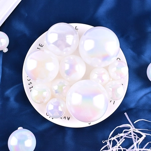 Close-up of iridescent pearlescent decorative balls on a white plate with blue fabric