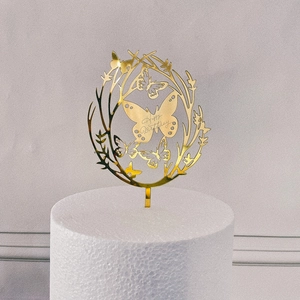 Detailed view of a golden acrylic butterfly wreath topper with Happy Birthday engraving