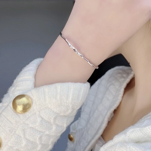 Minimalist S925 sterling silver wavy cuff bracelet with polished mirror finish on female wrist
